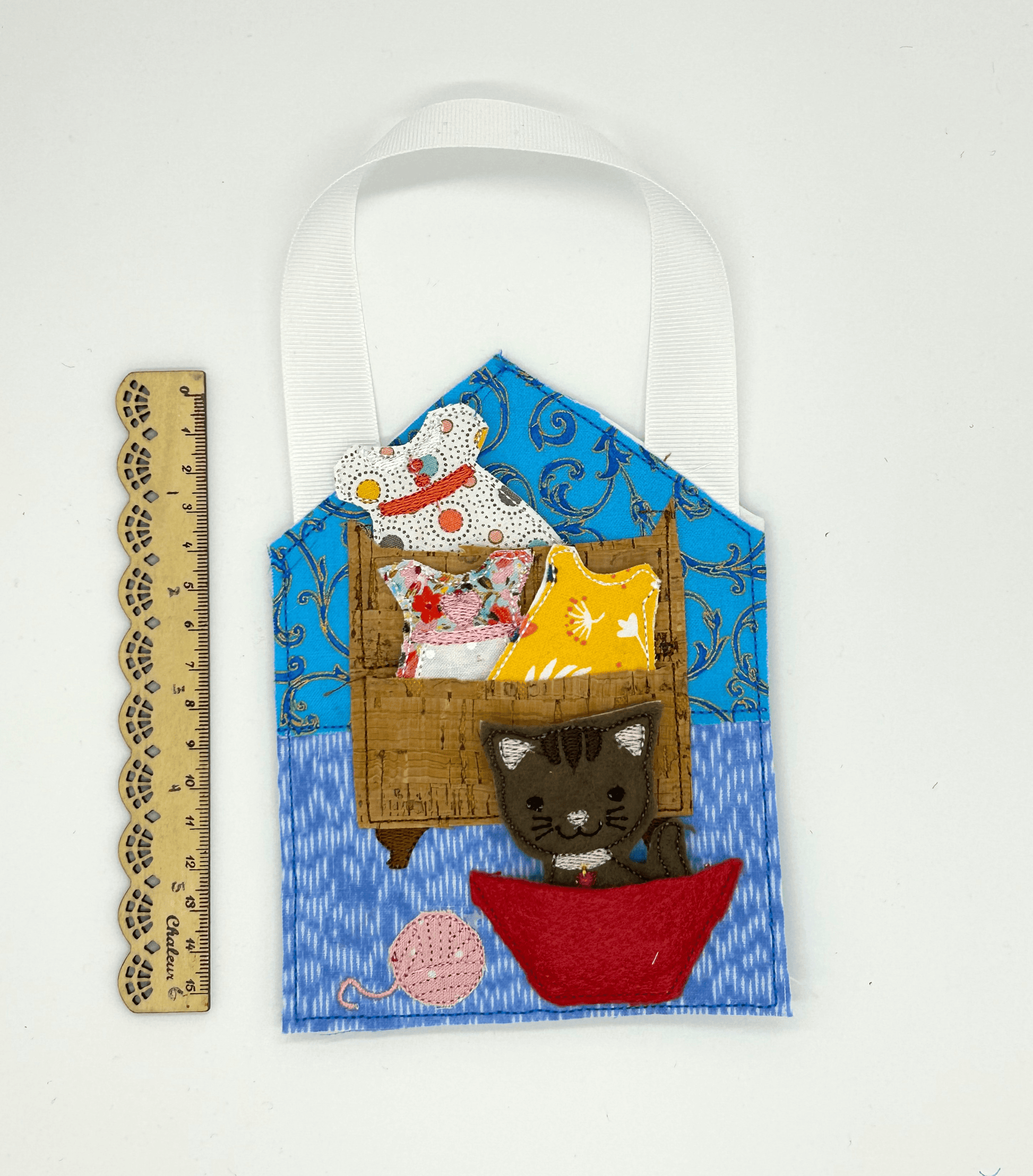 Felt and cloth "paper style" doll wardrobe and cat, beside ruler for scale